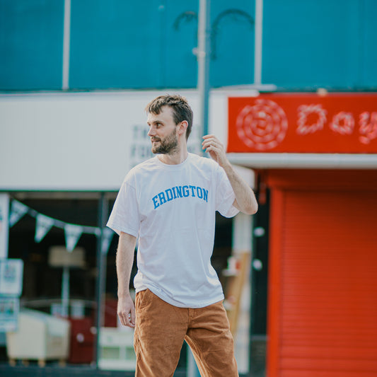 Luke Sewell wearing the Brumbox vintage athletic style Erdington white T-shirt walking down the Erdington high street