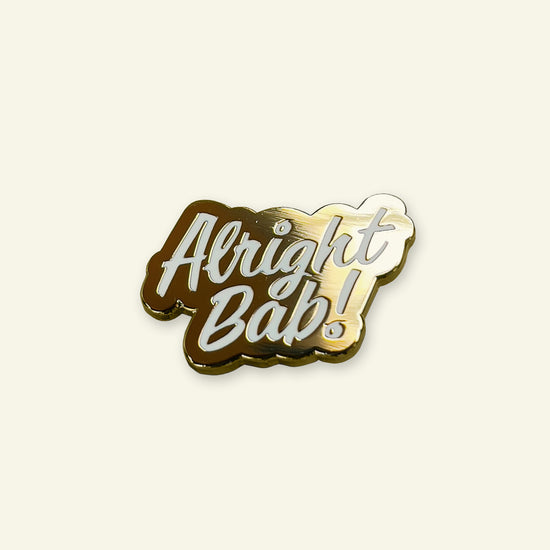 Brumbox gold coloured Alright Bab! enamel pin badge with white lettering.