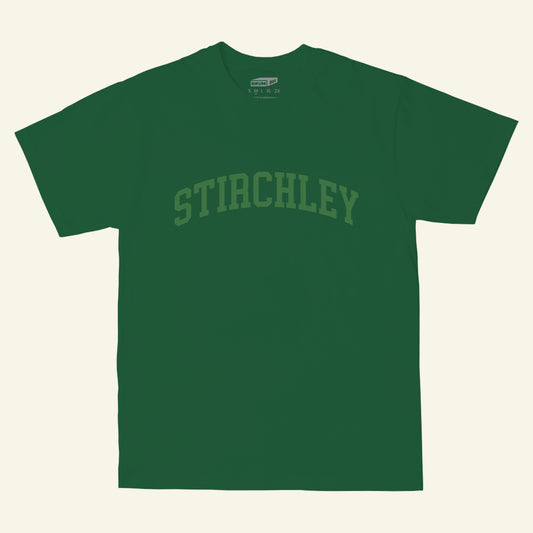 Stirchley athletic varsity style logo printed in light green on the chest of a green t-shirt (front)